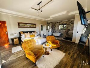 Starlight Inn Boutique Hotel في Humewood: غرفة نوم بسرير وكرسيين وحوض استحمام