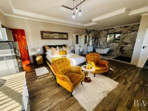 Starlight Inn Boutique Hotel في Humewood: غرفة نوم بسرير وكرسيين وحوض استحمام +80 صورة