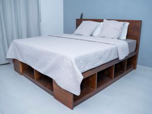 Appartement Cosy avec Balcon - Haie Vive في كوتونو: سرير عليه ملاءات ووسائد بيضاء