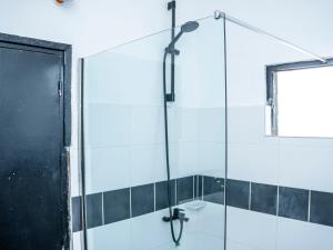 Appartement Cosy avec Balcon - Haie Vive في كوتونو: دش مع باب زجاجي في الحمام +13 صورة