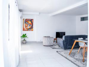 Appartement Cosy avec Balcon - Haie Vive في كوتونو: غرفة معيشة مع أريكة وطاولة