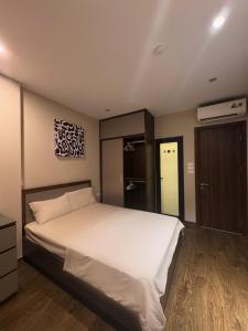 a bedroom with a large white bed and a closet at Studio 2 Byhomelinh Phố Cổ Hoàn Kiếm in Hanoi