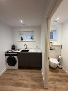 a kitchen with a sink and a washing machine at Luxury House, Great Location in Redditch - Contractors - Families - Groups - Relocators - Sleeps 9 in Bentley