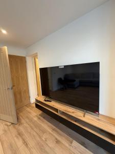 a living room with a large flat screen tv on a wall at Luxury House, Great Location in Redditch - Contractors - Families - Groups - Relocators - Sleeps 9 in Bentley