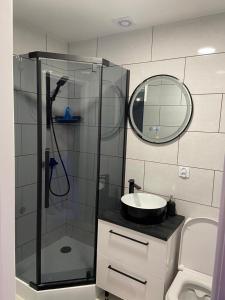 a bathroom with a shower and a sink and a mirror at Apartament na lipowej in Pastwiska