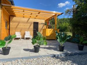 a patio with a wooden pergola and some plants at Apartament na lipowej in Pastwiska