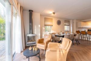 a living room with a fireplace and a dining room at Oude Dijkje in De Koog