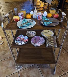 einen Tisch mit Teller mit Lebensmitteln und Obst darauf in der Unterkunft Hoeve de Haan in Bellingwolde