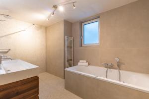 a bathroom with a tub and a sink and a window at Oude Dijkje in De Koog +13 photos