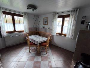 een eetkamer met een tafel, stoelen en ramen bij Ferienwohnung Angelika Zimmermann Dettelbach in Dettelbach +5 foto's