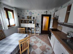 een keuken met een tafel en stoelen in een kamer bij Ferienwohnung Angelika Zimmermann Dettelbach in Dettelbach