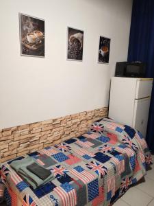 a bed with a patriotic quilt and a refrigerator at Casa PALLINA FIDENZA in Fidenza