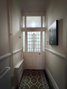 a hallway with a door with a stained glass window at Stylish, Spacious City Hideaway - Sleeps up to 9 in Cardiff