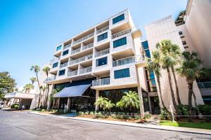 a tall building with palm trees in front of it at Bay Club of Sandestin in Destin