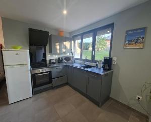 a kitchen with a white refrigerator and a sink at Le Refuge des Dunes in Bray-Dunes +6 photos