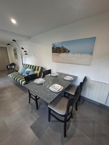 ein Wohnzimmer mit Tisch und Couch in der Unterkunft Le Refuge des Dunes in Bray-Dunes