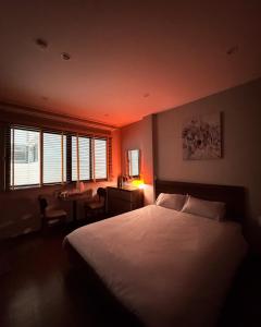 a bedroom with a bed and a desk and window at Studio 3 ByhomeLinh Phố Cổ Hoàn Kiếm in Hanoi