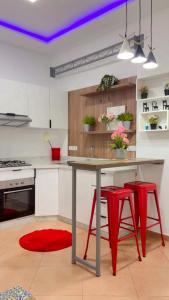 a kitchen with a table and two red stools at Elégance & Confort in Rabat +19 photos