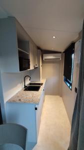 eine kleine Küche mit einer Spüle und einer Theke in der Unterkunft Tiny-housse in Peyrins