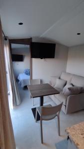 ein Wohnzimmer mit Sofa und Tisch in der Unterkunft Tiny-housse in Peyrins