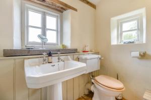 ein Badezimmer mit Waschbecken und Toilette und einem Fenster in der Unterkunft 3 Bed in Newton St. Margarets oc-o33367 in Saint Margaret