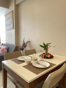 ein Esstisch mit Tellern und Schalen mit Obst darauf in der Unterkunft The Beach Suite at The Mactan Newtown in Lapu Lapu City