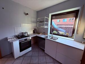 a small kitchen with a sink and a window at FeWo 5Z Terasse 2 Bad in Lingen +3 photos