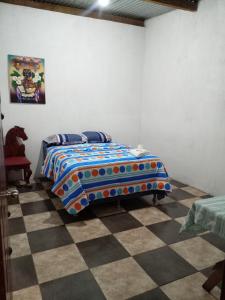 a bedroom with a bed and a checkered floor at Hospedaje Tiyox Aab'aj in San Juan La Laguna