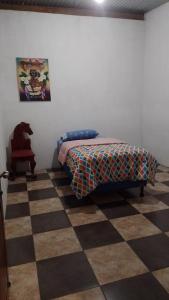 a bedroom with a bed and a checkered floor at Hospedaje Tiyox Aab'aj in San Juan La Laguna