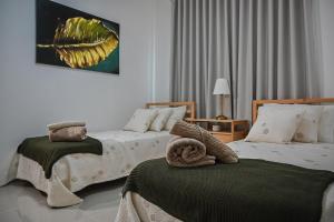 a bedroom with two beds with towels on them at Ecos del Mar 2 - Villa 7 · Modern 2BR Villa in Downtown Punta Cana in Punta Cana