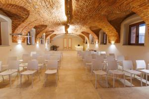 een kamer met rijen tafels en stoelen in een gebouw met een zichtbaar plafond bij La Corte del SignorB 