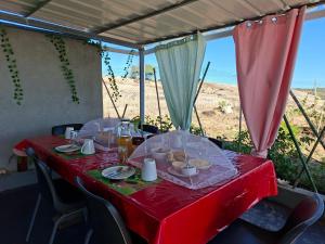 einen Tisch mit einem roten Tischtuch mit Futter drauf in der Unterkunft Papol et Tella guesthouse in Saint Francois