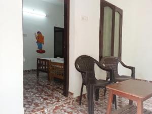 a room with two chairs and a table and a mirror at Jickys Nest in Varkala