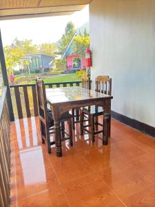 Ban Na Yangอินทนนท์ บ้านพักเล่าจู Inthanon Laoju House的门廊上的木制餐桌和椅子