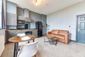 a kitchen and living room with a table and a couch at Apartment Stays in Newcastle upon Tyne