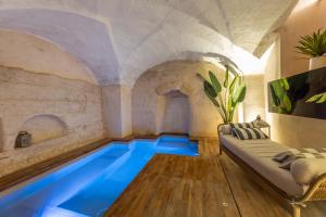 an indoor swimming pool with a couch in a room with an indoor at SuiteCota24 piscina e spa in Lecce