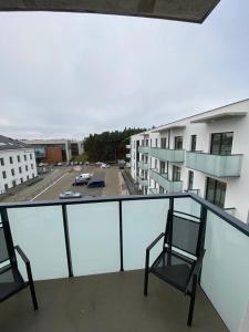 un balcone con 2 sedie e un posto auto di Apartament Kołobrzeska 2 a Piła