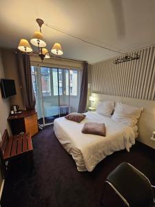 a hotel room with a large bed and a window at Hôtel 1er Consul Rouen in Rouen