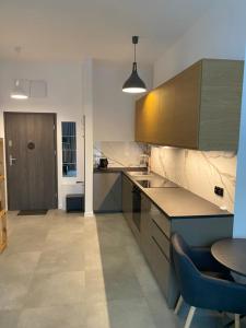 a kitchen with brown cabinets and a table in it at Apartament Kołobrzeska 2 in Piła