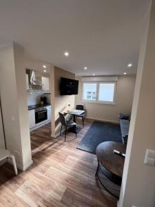 a living room with a table and chairs and a kitchen at Lumio Apartment 2 - Klimatisiert - Coffee for free - in Karlsruhe +51 photos