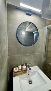 ein Badezimmer mit Waschbecken und Spiegel in der Unterkunft Aristotelous Elysian House in Thessaloniki