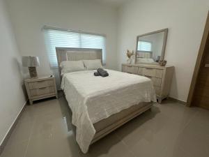 a bedroom with a large bed and a mirror at Ecos del Mar 1 - Villa 31 · 3BR Tropical villa near Downtown in Punta Cana