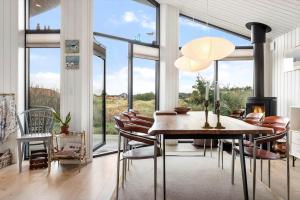 a dining room with a table and chairs and a fireplace at 1071-Thisted-Gravsesvej-30 in Klitmøller +13 photos