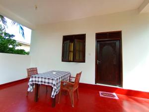 a room with a table and two chairs and a door at Allan Guest Mirissa in Bandaramulla +56 photos