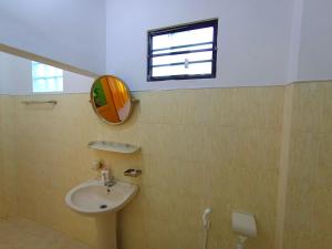 a bathroom with a sink and a mirror and a window at Allan Guest Mirissa in Bandaramulla