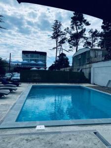 a large blue swimming pool in a yard at Villas David in Ureki