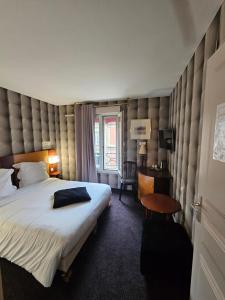 a hotel room with a large bed and a desk at Hôtel 1er Consul Rouen in Rouen