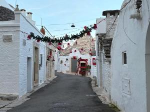 an alley with christmas lights and garland in an alley at Trullo La Visita Meravigliosa in Alberobello +9 photos