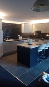 a large kitchen with white cabinets and a island in it at Luxurious Double En-Suite Tralee Town Centre in Tralee