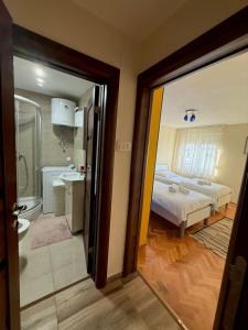 a bedroom with a bed and a bathroom with a tub at Milenijum apartman in Podgorica